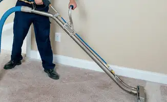 Professional operating a liquid removal machine on a carpeted floor in ,